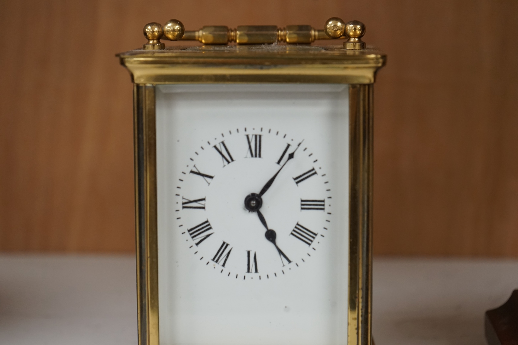 An Edwardian inlaid mahogany balloon clock and a brass cased carriage timepiece, largest 23cm high. Condition - fair, untested